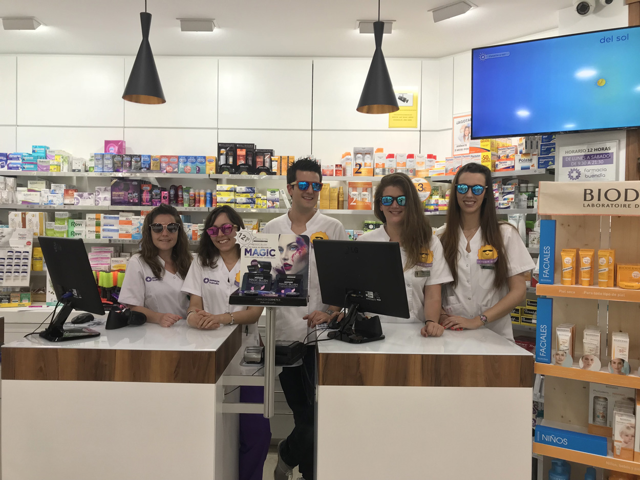 Farmac&eacute;utica con los brazos apoyados en el mostrator sonr&iacute;e